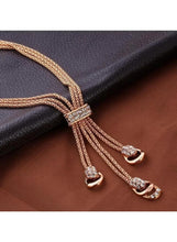 Gold-tone crystal tassel pendant necklace with matching hoop earrings closeup