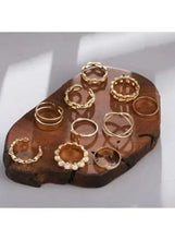 Gold-tone fashion ring set with multiple stacked rings, circular and heart accents