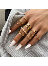 Gold-tone rings on hand with pearl beads and butterfly charm, plus thin bands