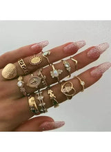 Gold-tone boho ring set on hand, featuring circular medallion and heart rings