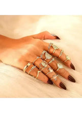 Gold-tone boho ring set on hand, featuring heart and bezel-style rings