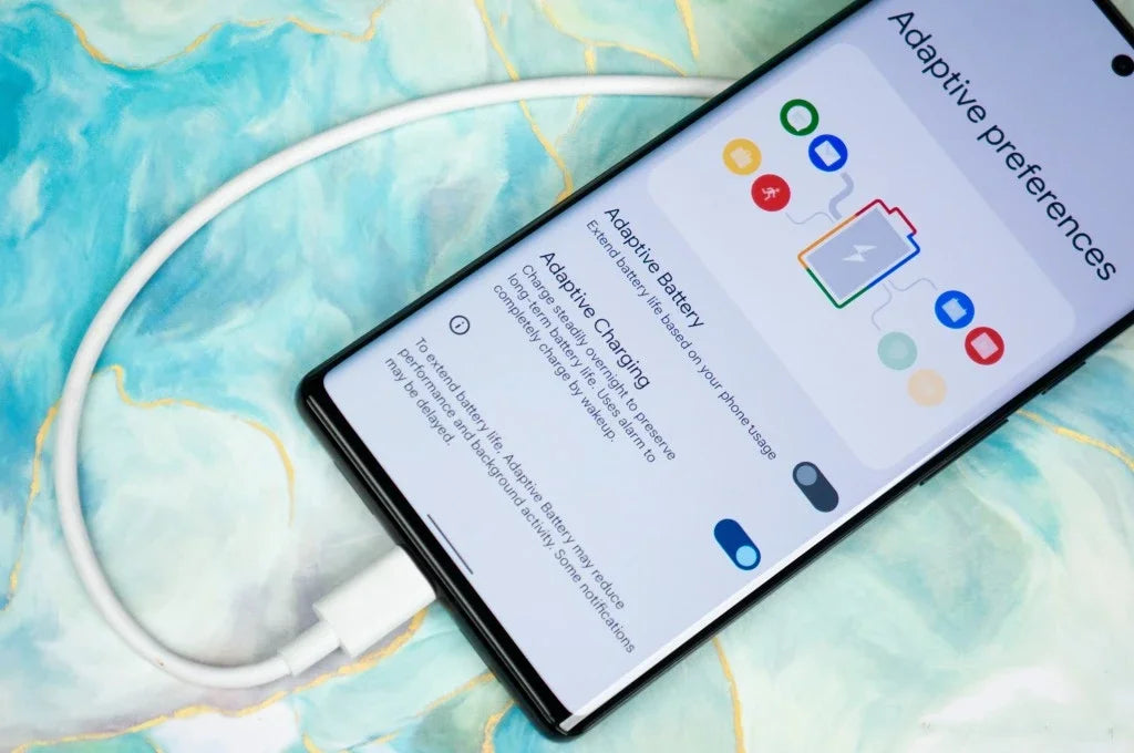 Google Pixel 6 Pro 5G unlocked smartphone charging via white USB C cable showing Adaptive battery settings on screen