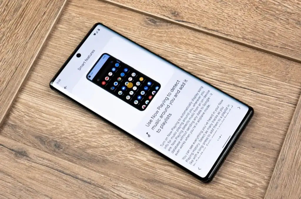 Google Pixel 6 Pro 5G unlocked lying on a wooden surface showing the display with app icons and front camera