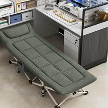 Folding camping cot with green cushioned mattress and open steel frame