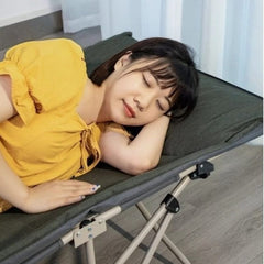 Huitich green folding camping cot with metal frame supporting a woman resting indoors