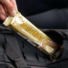 Protein bar held by hand in gold wrapper with Caramel Chaos label