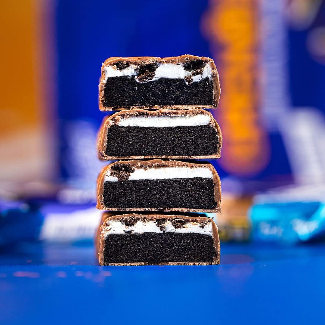 Four stacked cross sections of a grenade oreo protein bar showing chocolate coating dark cookie and cream layers