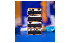 Grenade Oreo protein bars stacked cross section showing chocolate coating cookie core and cream filling