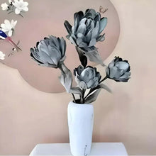 Artificial flower bouquet in white vase with five dark grey blooms on tabletop