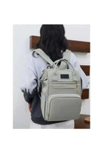 Light grey baby travel backpack with front zipper pocket and top handle