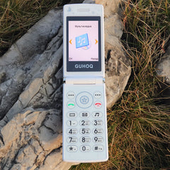 Mumzar women flip phone dual sim white clamshell handset open on rock showing keypad and music screen
