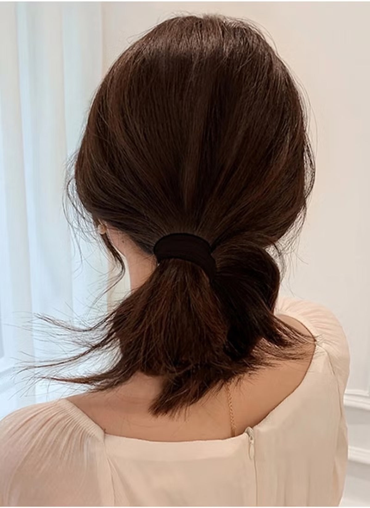 Huitich hair ties for thick hair pack of 20 in black used to secure a low ponytail on dark brown hair