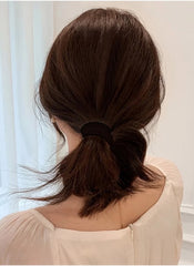 Huitich hair ties for thick hair pack of 20 in black used to secure a low ponytail on dark brown hair