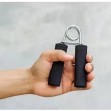 Black foam grip strengthener with metal spring loop, close-up in hand
