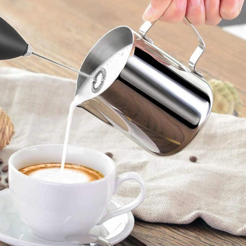Huitich handheld mixer for baking creates frothy milk for coffee in a white cup on wooden table