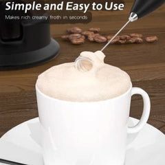 Handheld mixer for baking frothing milk to create rich creamy coffee foam in a white cup