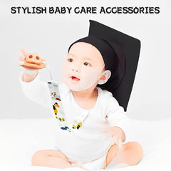 Baby in white onesie wearing black graduation cap holding colorful animal print baby pacifier clips set