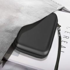 Black hard disk carrying case for travel with zipper and wrist strap partially tucked under a gray bag