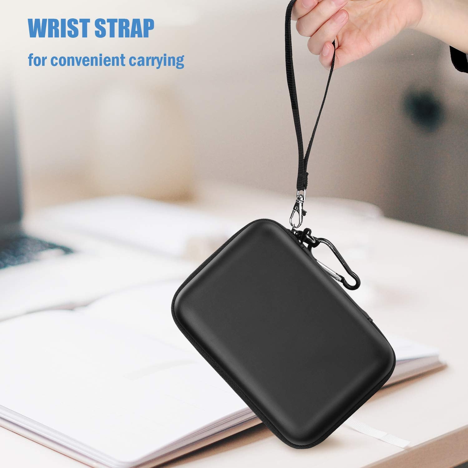 Black hard disk carrying case for travel with wrist strap held by hand for convenient carrying