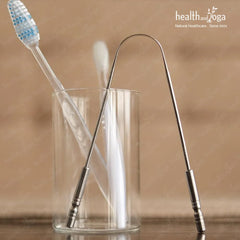 HealthAndYoga metal tongue cleaner stainless steel tongue scraper standing in glass with toothbrush