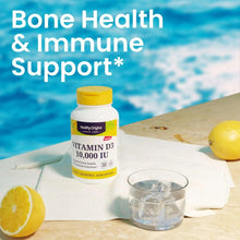 Vitamin D3 10,000 IU softgel bottle with water glass and lemon on table