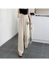 Beige high-rise lightweight pants with pleated front and drapey wide legs
