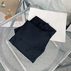 Mumzar high waist yoga leggings UAE folded neatly on a glass table, showcasing their sleek design