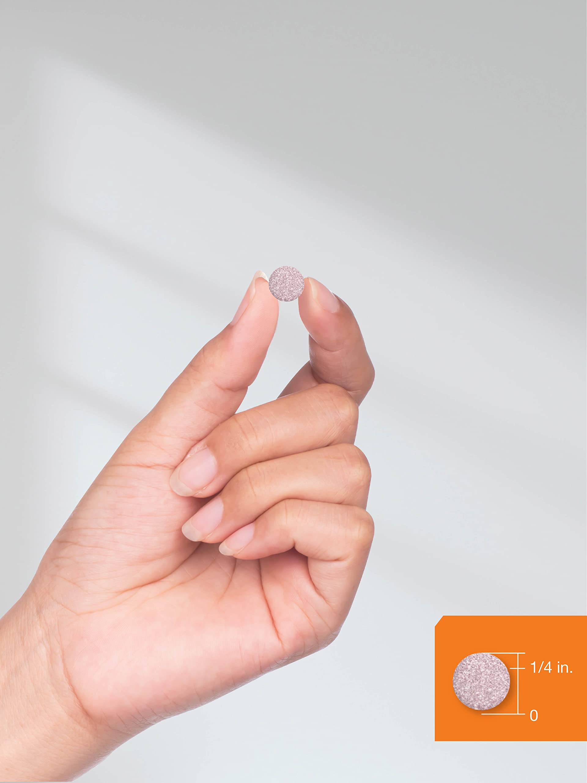 B12 sublingual tablets 5000mcg small round pink tablet held between fingers showing size