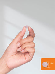 B12 sublingual tablets 5000mcg small round pink tablet held between fingers showing size