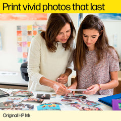 Mother and daughter looking at printed photos using original HP ink for DeskJet printers