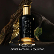 Perfume bottle with dark glass and gold cap, embossed logo by green leaves