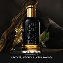 Parfum bottle with black glass and gold cap, with leather and leaf accents.