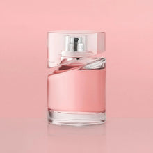 Pink perfume bottle with silver collar, clear atomizer, and reflective base