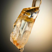 Amber perfume liquid splash with glossy drop and gold-toned nozzle