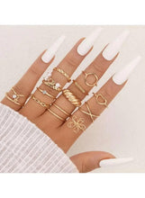 Gold-tone ring set worn on hand, twisted and square bands with pearl accents