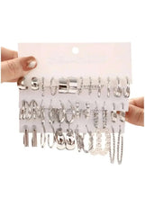 Silver-tone mixed hoop and stud earrings on display card, various sizes and shapes