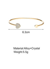Gold-tone bracelet bangle with round crystal center and small heart-shaped end