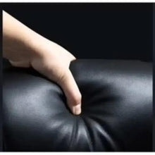 Dark leather office chair seat with stitched padding, close-up