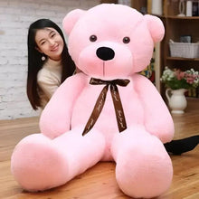 Pink teddy bear plush sitting with dark ribbon bow and stitched eyes