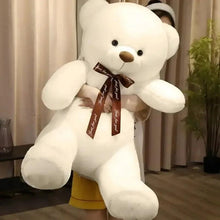 White teddy bear plush with brown ribbon bow, tilted seated pose