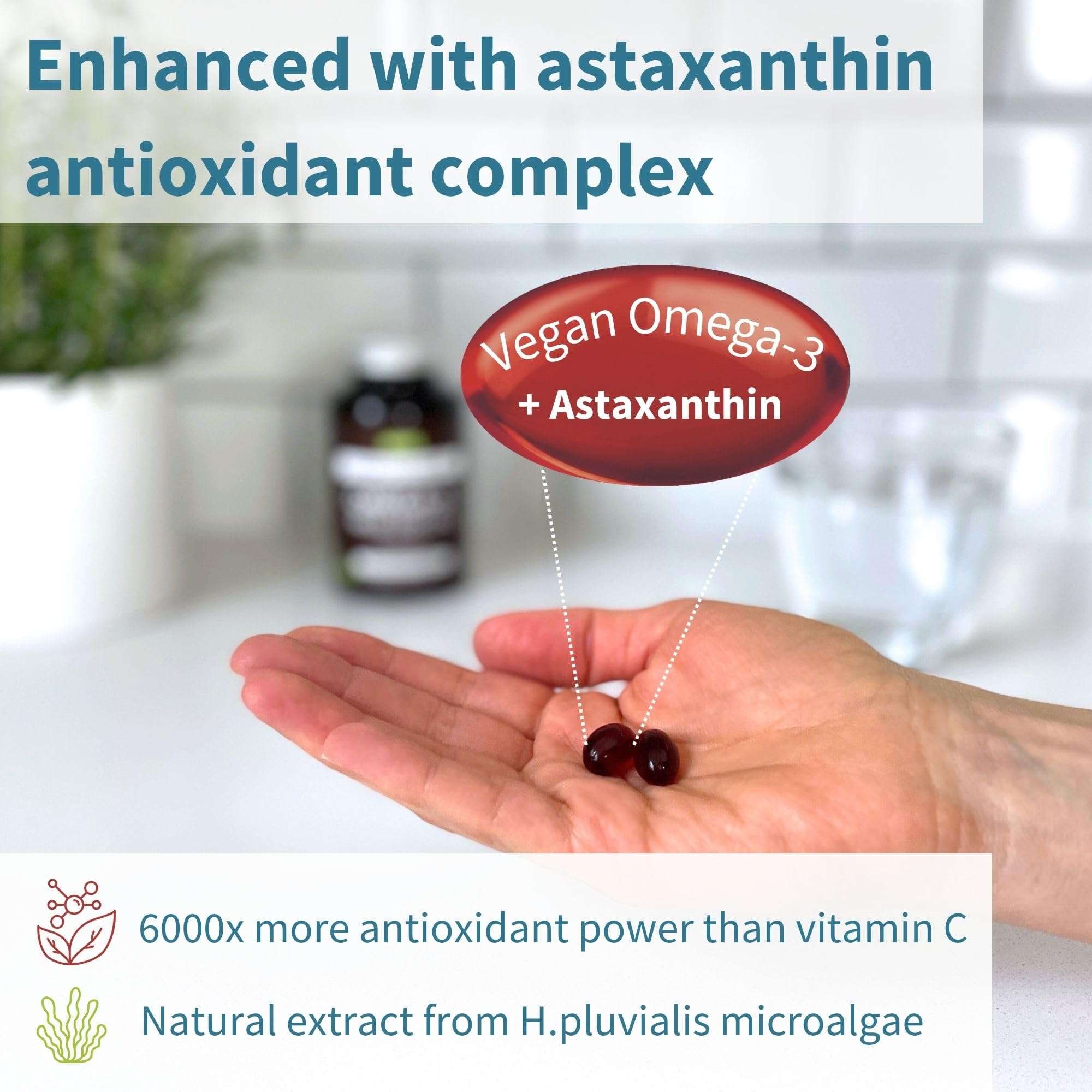 Igennus hand holding two dark softgel capsules with astaxanthin vegan omega 3 supplement UAE