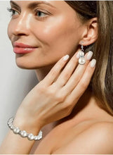 Imitation pearl earrings with matching bracelet on model, silver-toned bead details