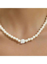 Faux pearl necklace with round sparkling charm at center