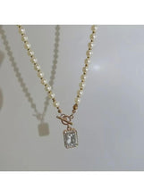 Imitation pearl necklace with gold-tone hook charm and square pendant