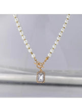 Imitation pearl necklace with gold-tone clasp and square crystal-like pendant