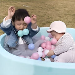 Two toddlers playing in a blue ball pit filled with colorful indoor kids play balls 50 pack by Huitich