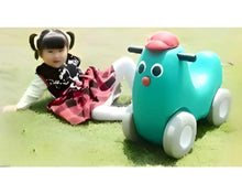 Teal plastic toy dog ride-on car with red top, white wheels, and a seated child