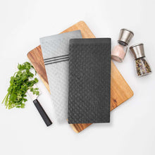 Set of striped cotton kitchen towels, dark gray and white, on wooden boards
