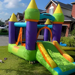 Colorful inflatable bouncy castle for kids with slide and turrets set up on grass outside a house