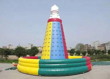 Inflatable climbing slide with tall yellow and red tower and wide green base on ground